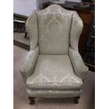 ANTIQUE UPHOLSTERED WINGBACK ARMCHAIR ON BALL AND CLAW FEET