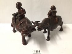 TWO VINTAGE ORIENTAL CARVED WOOD FIGURES OF OXEN WITH RIDERS. LARGEST 18CM IN HEIGHT.