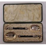 A cased set of silver and ebony serving spoons with cast Kiwi terminals, Birmingham 1924
