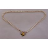 A freshwater pearl necklace with 15ct yellow gold and diamond shell shaped clasp