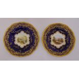A pair of Coalport X2289 dessert plates signed by E O Ball, decorated with landscapes surrounded