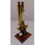 A Victorian brass microscope mounted on a rectangular wooden plinth 46cm (h)
