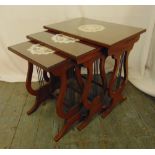 A nest of three rectangular mahogany side tables with glass tops, lyre sides with scroll supports,