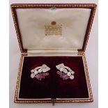A pair of diamond and ruby earrings set in white gold tested 18ct, retailed by Garrards in