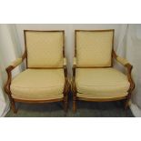A pair of continental upholstered armchairs with scrolling yew wood arms on turned legs
