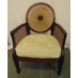 An Art Deco style mahogany and bergere armchair with upholstered seat on four rectangular spade