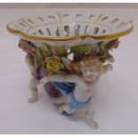 A continental pot pourri holder mounted on three putti figurines, marks to the base, 11 x 14cm