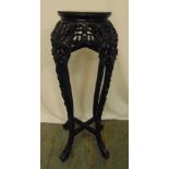 A Chinese hardwood plant stand with inlaid marble top, pierced and profusely carved with prunus