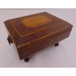 A walnut and fruit wood rectangular jewellery box with side handles and hinged cover on four ball