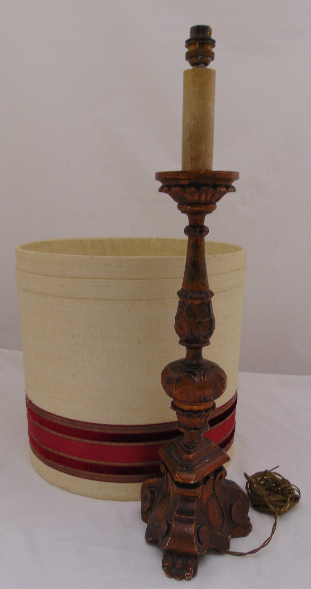 A carved wooden table lamp on triform base with detachable shade, 62cm (h)