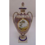 A continental oval vase with two side handles and raised pull off cover, the sides decorated with