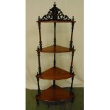A Victorian mahogany four tier corner whatnot, scroll pierced with turned column supports on three