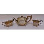 A silver three piece teaset of elongated octagonal form on claw feet, Sheffield 1937 by Edward