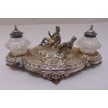 A Victorian silver plated ink stand, oval chased with birds and feathers with central figurines of a