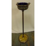 A brass free standing smokers stand on raised circular base with detachable blue glass bowl, 66cm (