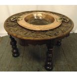 A 19th century continental oak circular table carved with figures and scrolls the centre inset