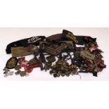 A quantity of WWI and WWII militaria to include trench art, badges, cap and shoulder insignia