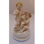 A continental porcelain figural group of putti on raised circular base, 19cm (h)