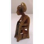 A West African horn carving of a figure seated on a chair 13cm (h)