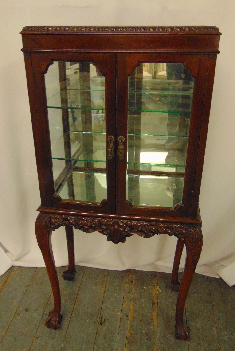 A mahogany glazed mirrored back display cabinet, on four cabriole legs, 126 x 61 x 35cm