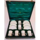 A cased set of six Crown Staffordshire coffee cups and saucers with hallmarked silver holders