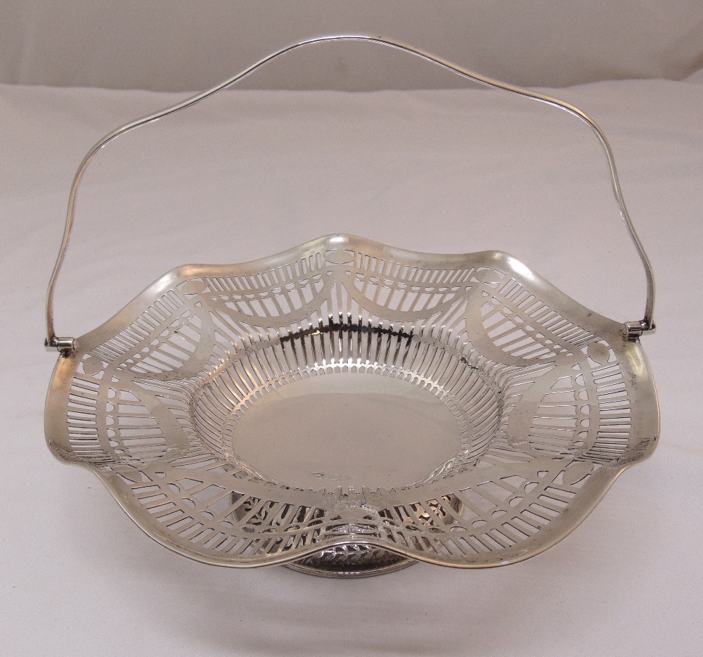 A silver fruit basket with pierced sides, swing handle on pierced circular base, Sheffield 1964,