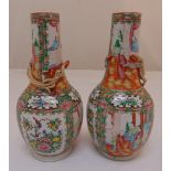 A pair of famille rose vases, decorated with figures, flowers, leaves and applied dragon
