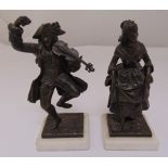A pair of bronze figurines of a man playing a violin and a lady dancing, both mounted on marble