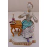 Meissen figurine of a lady seated at a table, marks to the base 13cm (h)