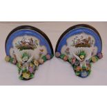 A pair of porcelain and wooden wall sconces decorated with floral clusters and painted exterior