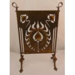 A rectangular Arts and Crafts hand hammered and pierced copper fire screen on four outswept legs,