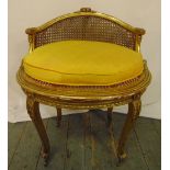 A gilded wooden and bergere French boudoir chair of oval section on four cabriole legs, 67 x 54 x