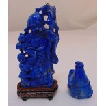 Two carved oriental lapis lazuli figurines to include a figural group on hardwood base a stylised