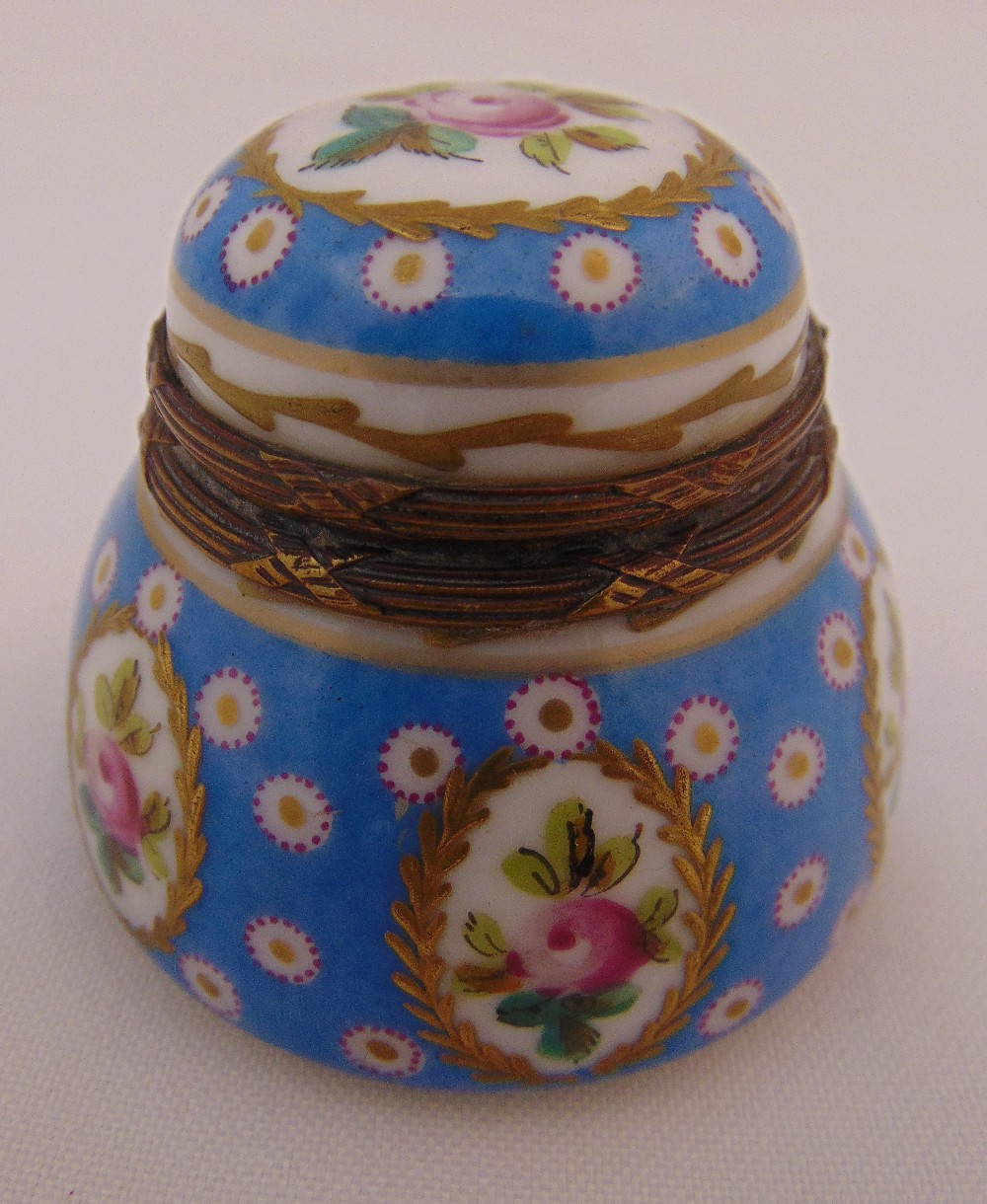 A Sevres circular covered inkwell decorated with floral sprays and domed hinged cover, marks to