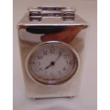 A hallmarked silver desk clock, rectangular with swing handle on four bun feet, white enamel dial,