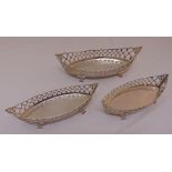 A suite of three matching oval hallmarked silver bonbon dishes, scroll pierced sides on pierced