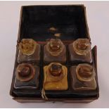 An early 20th century leather apothecary case with six glass bottles and drop stoppers, A/F