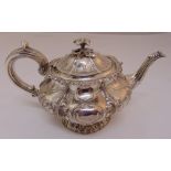 A George IV hallmarked silver teapot, compressed circular form, the lobed body chased with leaves