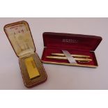 A Dunhill gold plated engine turned cigarette lighter in fitted case and a Sheaffer fountain pen and