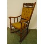 An oak rocking chair of customary form with upholstered seat and back, 109 x 56cm