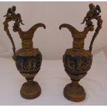 A pair of gilded metal ewers decorated with classical figures, vine leaves and grapes, the scroll