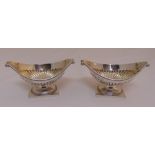A pair of late Victorian boat shaped hallmarked silver fluted salts on square bases, London 1885
