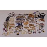 A quantity of costume jewellery to include necklaces, bracelets, earrings, brooches and pendants