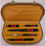 A cased Art Deco composition writing set comprising a seal, a pencil and a letter opener