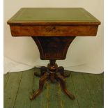 A Victorian rectangular walnut work table with hinged inset leather top on four carved scrolling