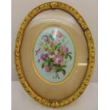 A framed and glazed oval porcelain panel hand painted with a spray of flowers, 21 x 16cm