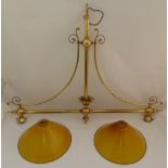 A brass snooker table light, the scrolling arms supporting two glass shades, 92 x 117cm