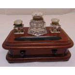 A Victorian rectangular walnut ink stand with three glass inkwells, a single drawer all on four