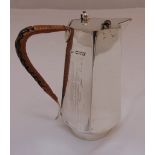 A hallmarked silver hot water jug, panelled sides with angled handle and gimbal mounted cover,