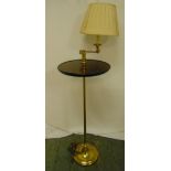 A brass and mahogany side table, circular on tubular stem with raised circular base and adjustable
